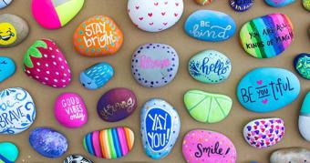A group of brightly painted rocks with positive messages.