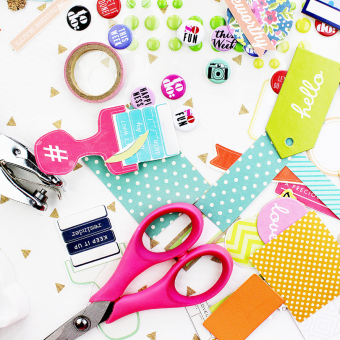 Scattered craft supplies, including paper, scissors, and stickers