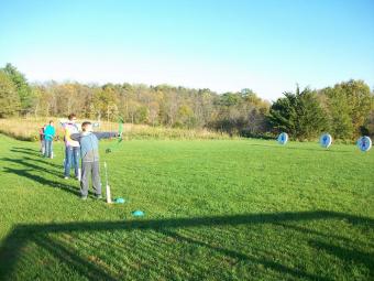 Three archers pointing their bow & arrows at zombie targets.