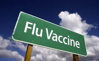 Image of a street sign that reads "Flu Vaccine"